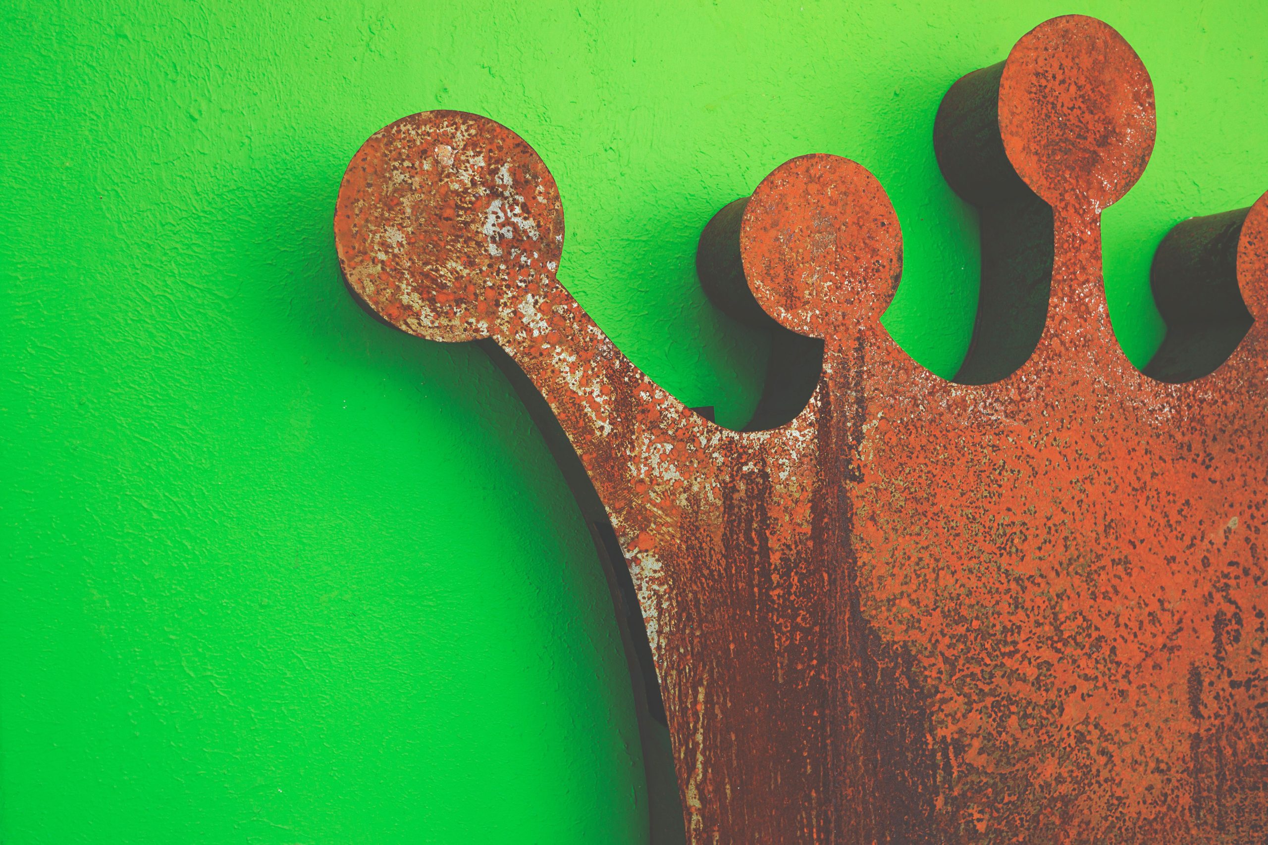 Couronne fer rouille mur vert contraste