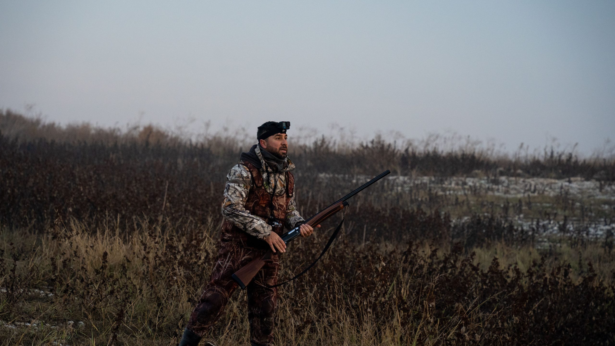 Chasseur équipé traversant champ brumeux matin