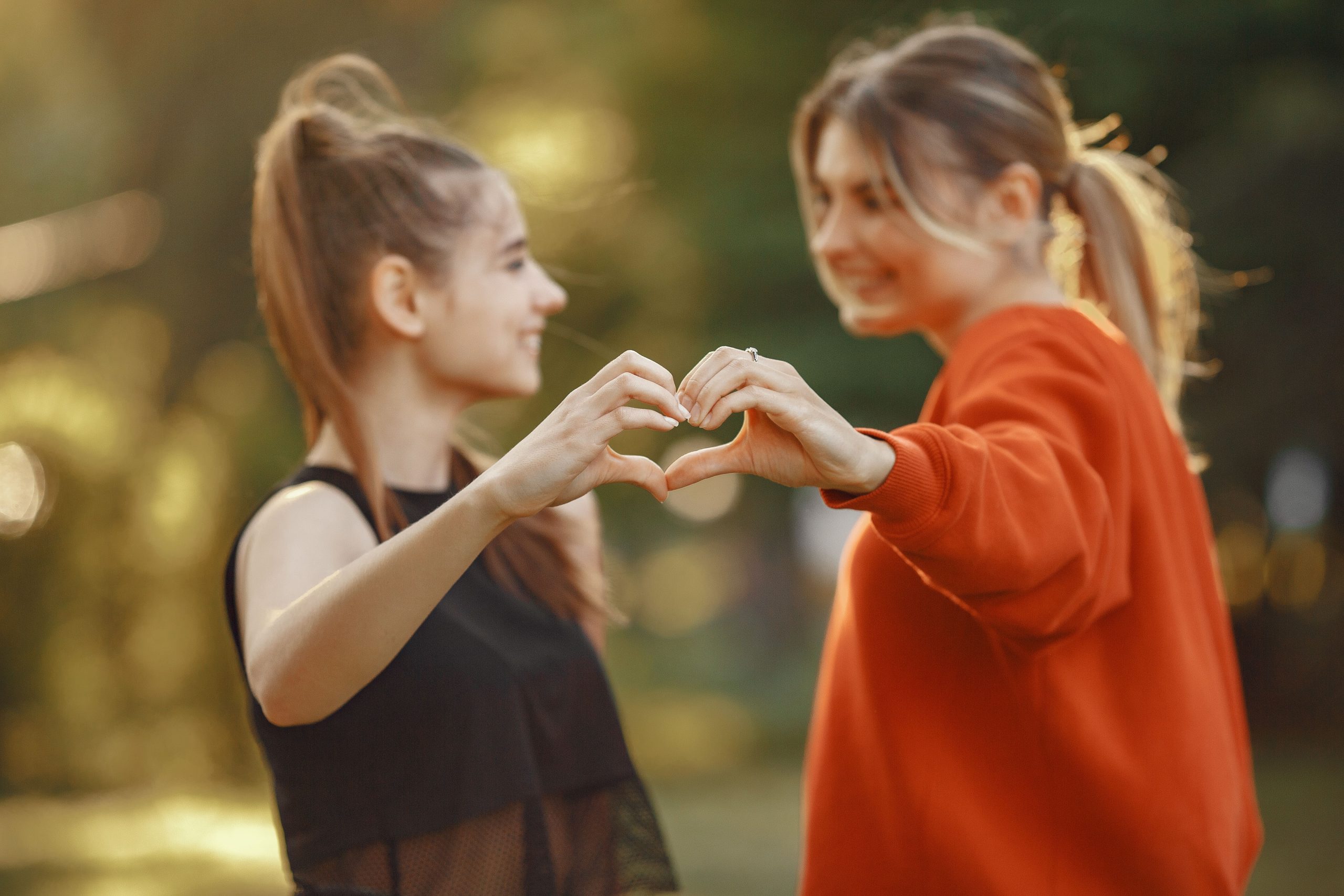 Deux femmes créent un cœur avec les mains