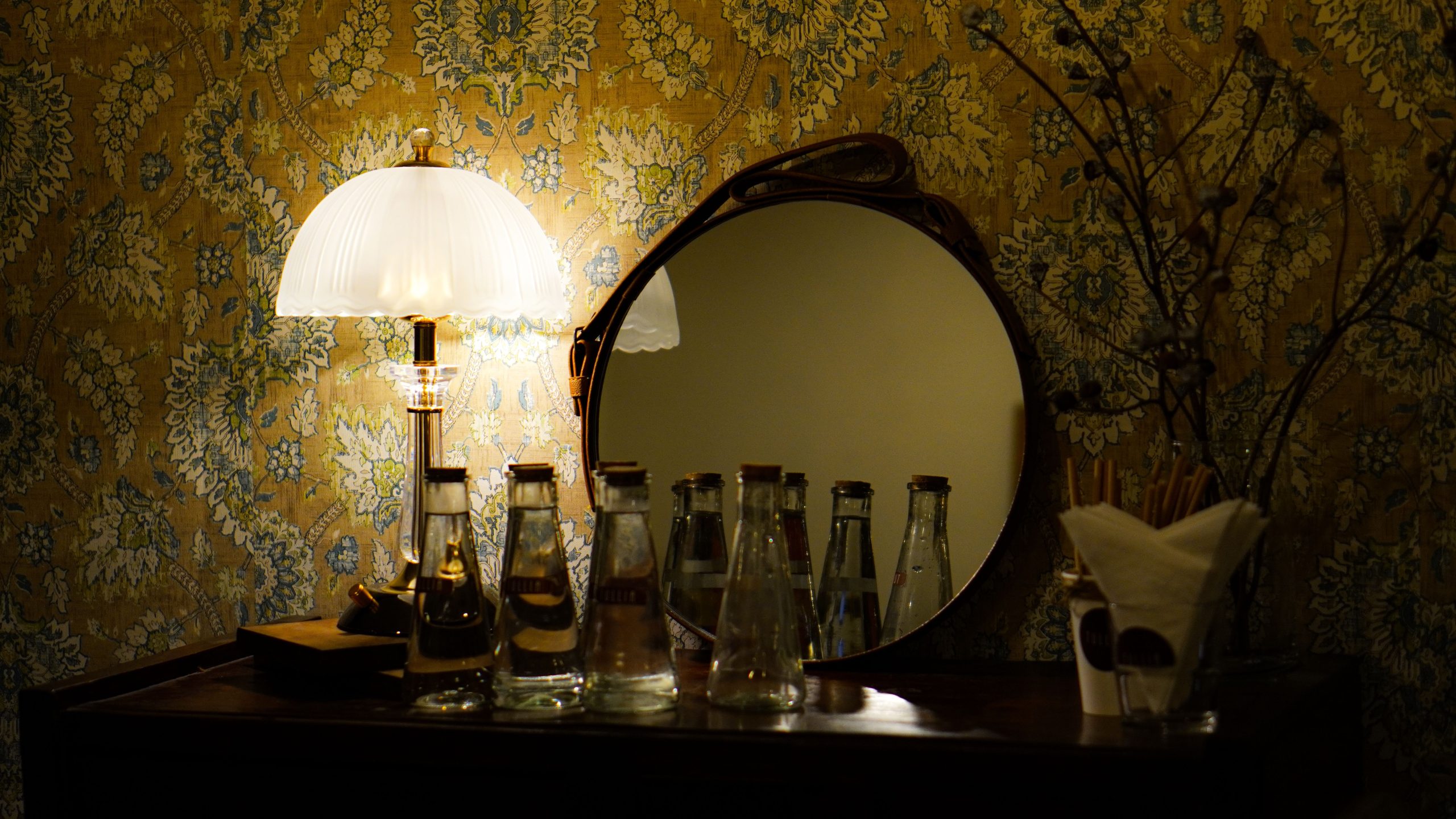 Lampe vintage décorée de bouteilles et miroir.