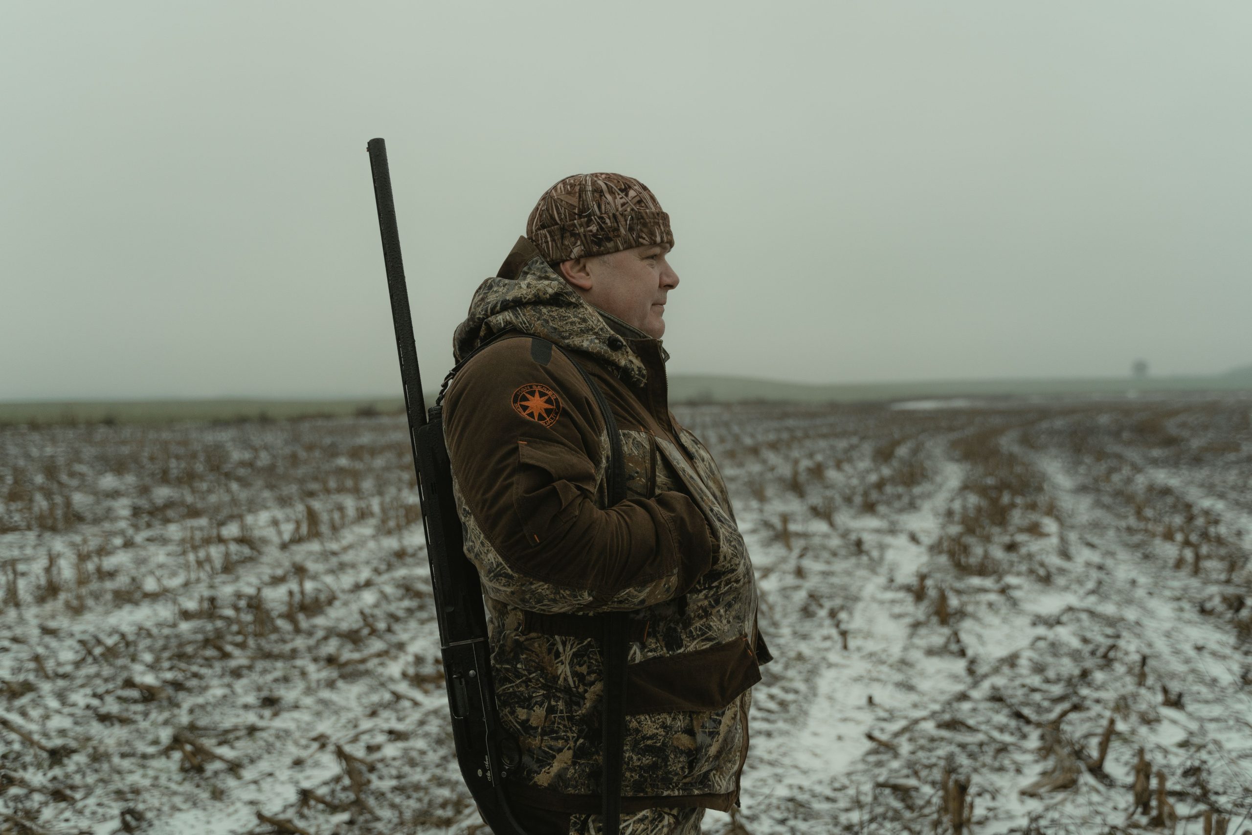 Chasseur en camouflage tenant un fusil neigeux