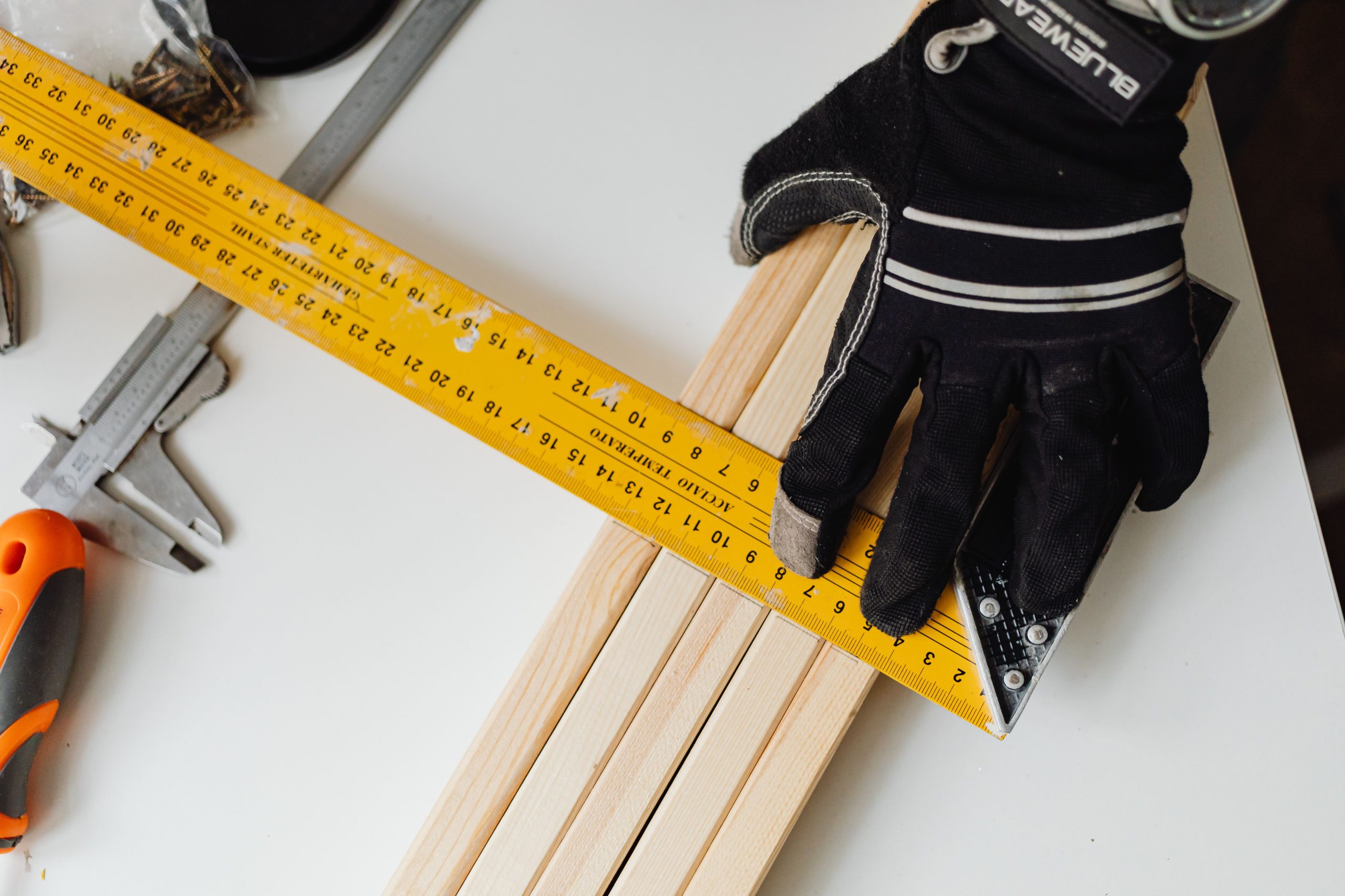 Main gantee utilisant outils de mesure sur bois