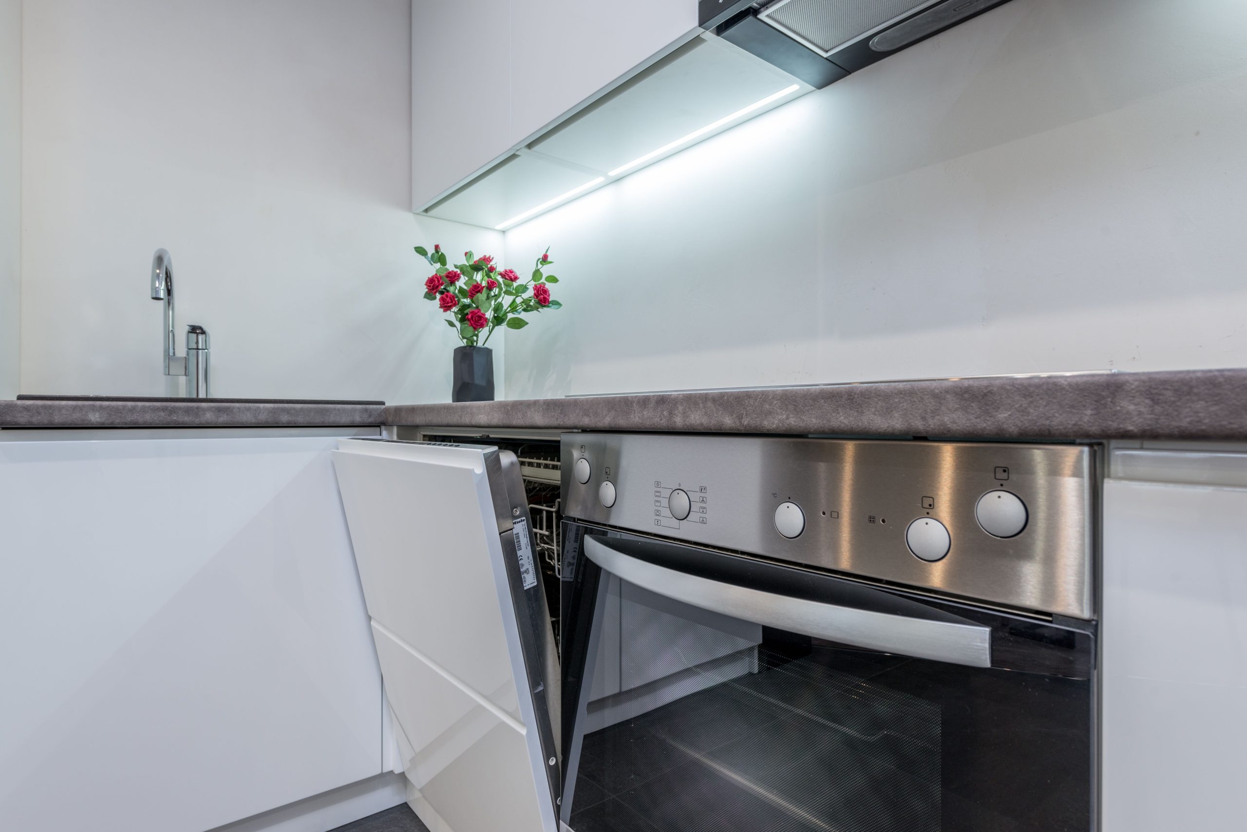 Cuisine avec lave vaisselle integrable ouvert et fleurs